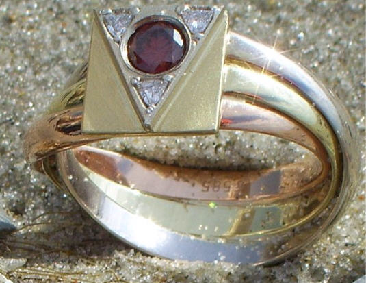 driekleur gouden Lemuri-ring met in de driehoek de zeldzame rode briljant die geflankeerd wordt door drie triljanten..